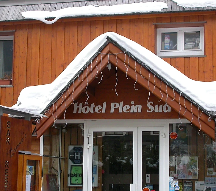 The timber front of Hôtel Plein Sud under fresh snow