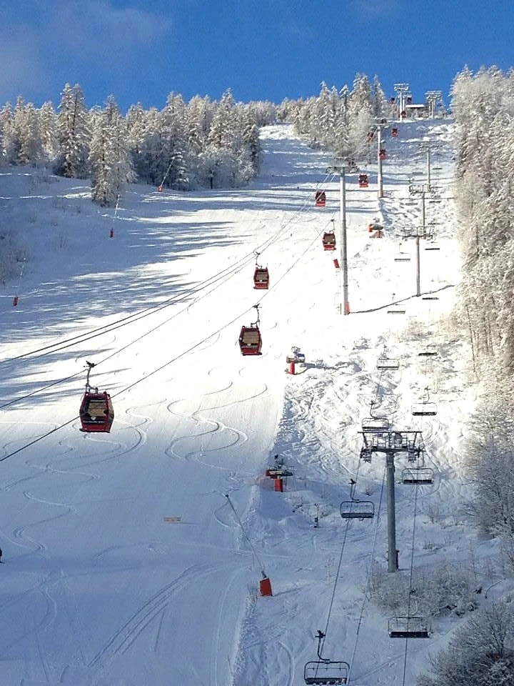 Gondola cabins crossing above a freshly groomed piste at Serre Chevalier