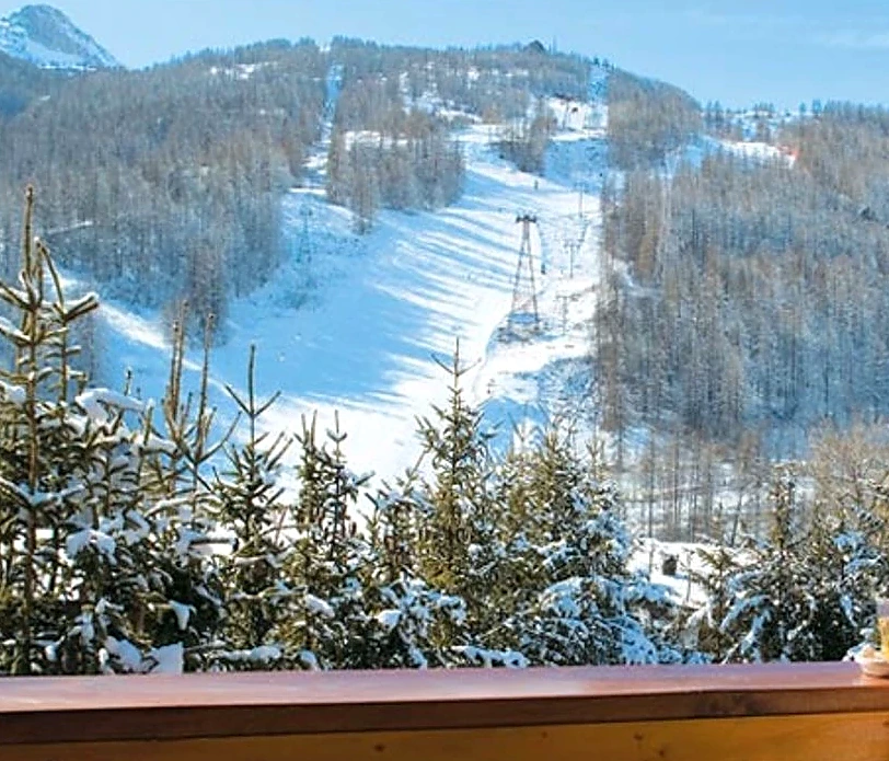 Looking across to the snow-covered piste and larches from a hotel balcony